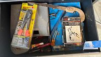 Drawer with packaged rivet gun, coping saw frame, boxed attachment, screwdrivers and misc tools