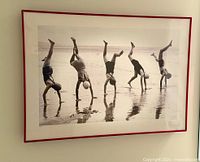 Full view of framed print on wall showing image content, mat and red frame