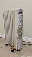 Full view of oil-filled radiator heater showing fins and wheels