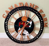 Entire wall clock showing CANADANE FARM lettering and farm motif center