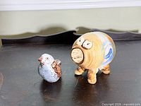 Pig coin bank and bird figurine on tabletop