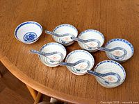 Six bowls and six matching spoons on wooden table