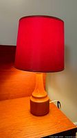 Lamp assembled showing pine base and illuminated red shade