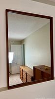 Front view of rectangular teak framed mirror