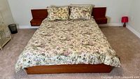Full view of bed frame, mattress, comforter and shams