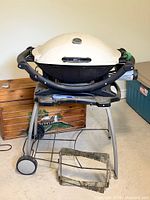 Front view of Weber natural gas grill on stand with hose visible