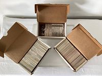 Three open storage boxes showing rows of hockey cards