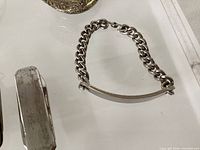 Close-up of ID bracelet curb links and part of pocket knife