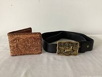 Belt with brass buckle and tooled leather wallet side by side