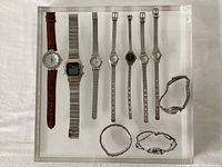 Tray overview showing 11 watches, mix of analog and digital