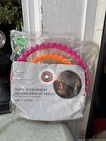 Front of sealed yarn accessories kit showing packaging and two circular looms