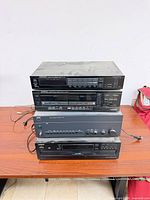 Front view of stacked Kenwood tuner, Kenwood cassette deck, NAD amplifier, Onkyo CD changer