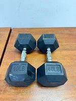 Pair of 40 lb rubber hex dumbbells side by side on wooden surface