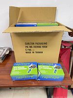 Open master carton showing multiple boxed rapitape RD6 tape dispensers on table