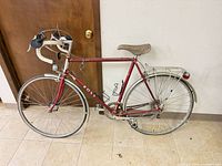 Full profile of red Ross road/touring bicycle showing frame, wheels, rack, fenders