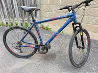 Right side profile of blue 26" mountain bike showing frame, wheels, drivetrain and overall condition
