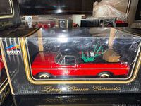 Front and side view of boxed red diecast pickup truck