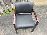 Front view of armchair showing vinyl upholstery and wood frame