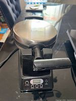 Salton waffle maker closed showing stainless lid, handle and digital control panel