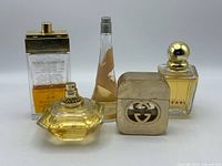 Front view of all five perfume bottles showing brands and fill levels
