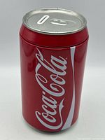Front view of red Coca-Cola tin piggy bank
