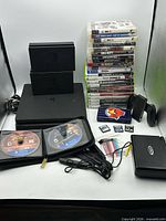 Overall lot view showing PS4, Switch docks, game stack, DS units, cartridges, stylus pack