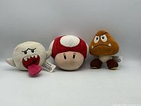 Front view of three Nintendo character plush toys Boo, Super Mushroom, Goomba