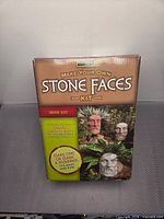 Front view of boxed Poetry Stones Make Your Own Stone Faces Kit Greek God