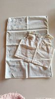 Top placed on pillowcase showing embroidery patterns and relative sizes