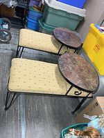 Pair of wrought iron benches showing upholstery and marble tops