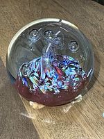 Overall view of clear glass paperweight on wood surface
