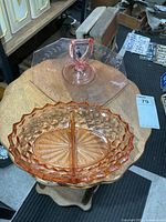 Both pink glass dishes on small table