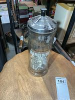 Full view of glass Barbicide jar with lid