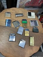 All twelve vintage lighters displayed on wooden board