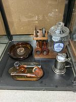 Group shot showing pipe stand with pipes, Tareyton jar, amber ashtray, brass tray, pipe tamper, stein lighter