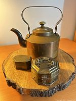 Copper/brass kettle, small plain brass box, octagonal vented brass box on wood slice