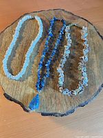 All three necklaces laid out on wood surface