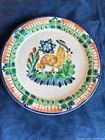Front view of hand-painted plate with rooster motif