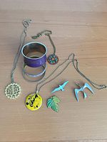 All nine jewelry items laid out grouping pendants, bracelets, brooches