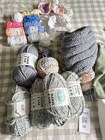 Yarn skeins, cotton balls, unfinished pieces displayed