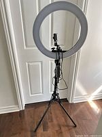 Front view of ring light on tripod with cable and phone holder visible