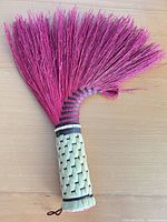 Full view showing pink bristles and woven handle