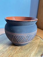 Full view of vase showing black matte exterior and incised geometric pattern