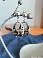 Front view of both earrings hanging, showing silver and abalone design