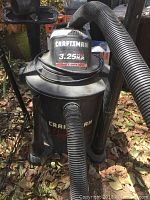 Front angled photo showing Craftsman wet/dry vacuum with branding and hose attached.