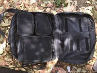 Black professional organizer bag with multiple compartments visible inside