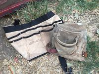 Photo of two canvas tool belts, one branded JDTools and another with reinforced leather pockets, used and worn