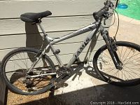 Full side view of silver Jamis Trail X mountain bike showing frame, saddle, drivetrain and tires