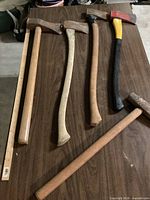 Five long-handled striking tools laid on table