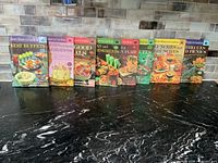 Eight Better Homes & Gardens cookbooks standing in a row, front covers visible